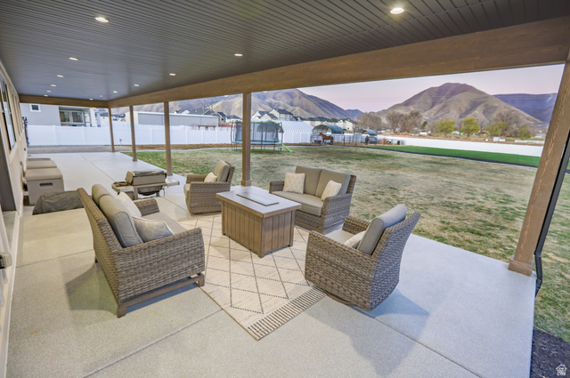 126 North 800 West Mapleton, UT 84664 - Photo 68 of 79 Patio terrace at dusk featuring a trampoline, a mountain view, a patio area, outdoor seating, and a fenced backyard