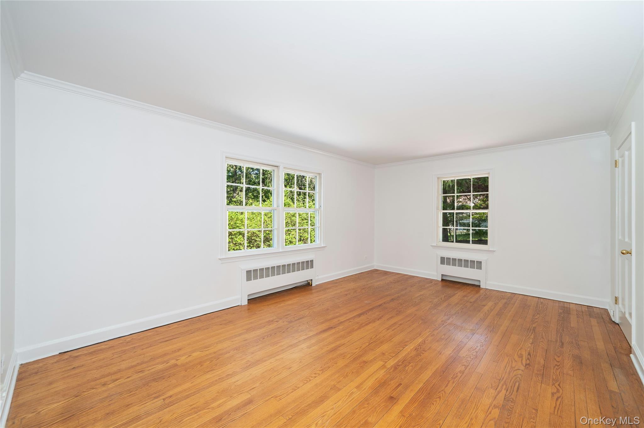 105 Douglas Road Chappaqua, NY 10514 - Photo 11 of 18 an empty room with wooden floor and windows