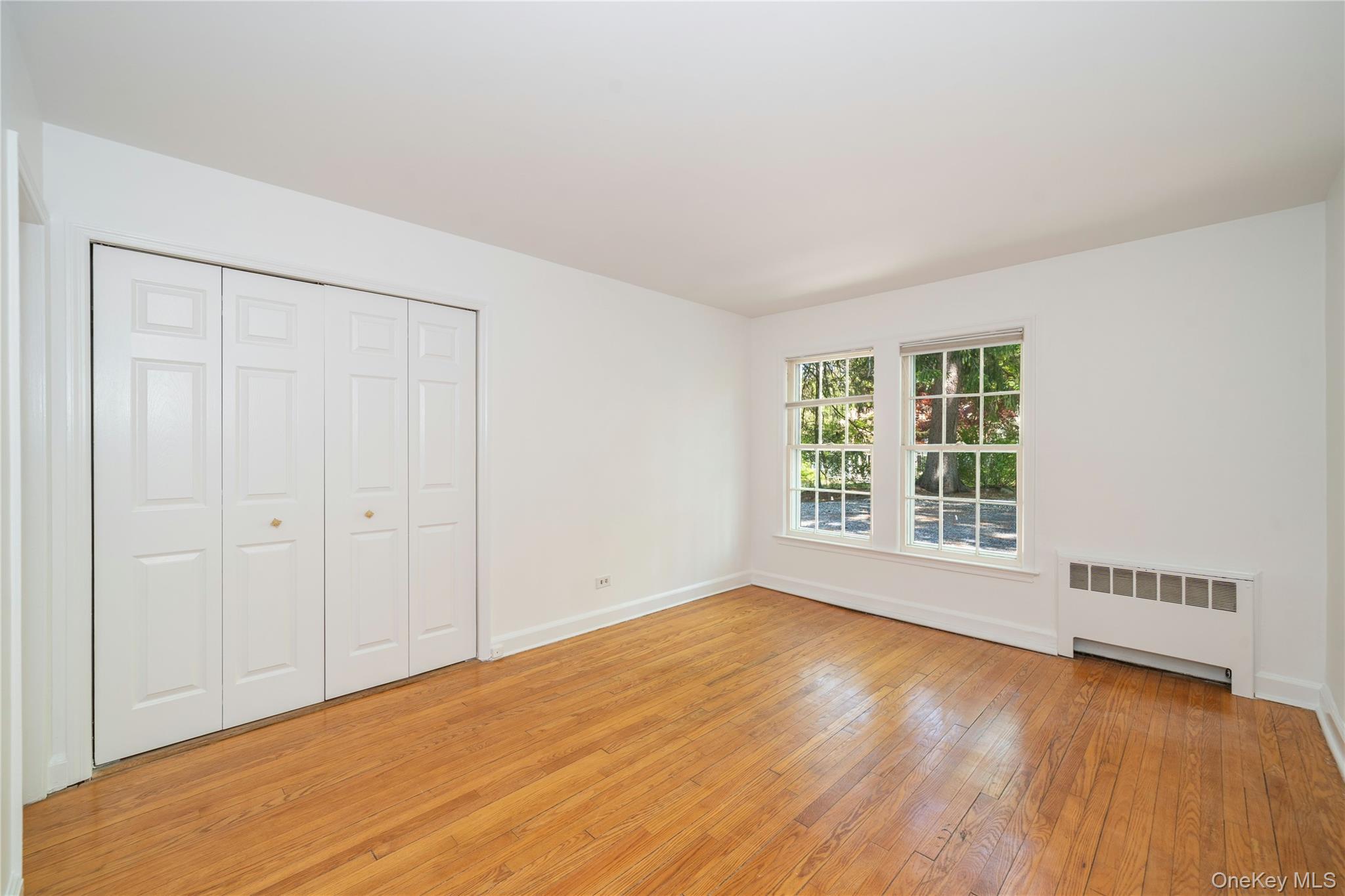 105 Douglas Road Chappaqua, NY 10514 - Photo 9 of 18 a view of an empty room with a window and wooden floor