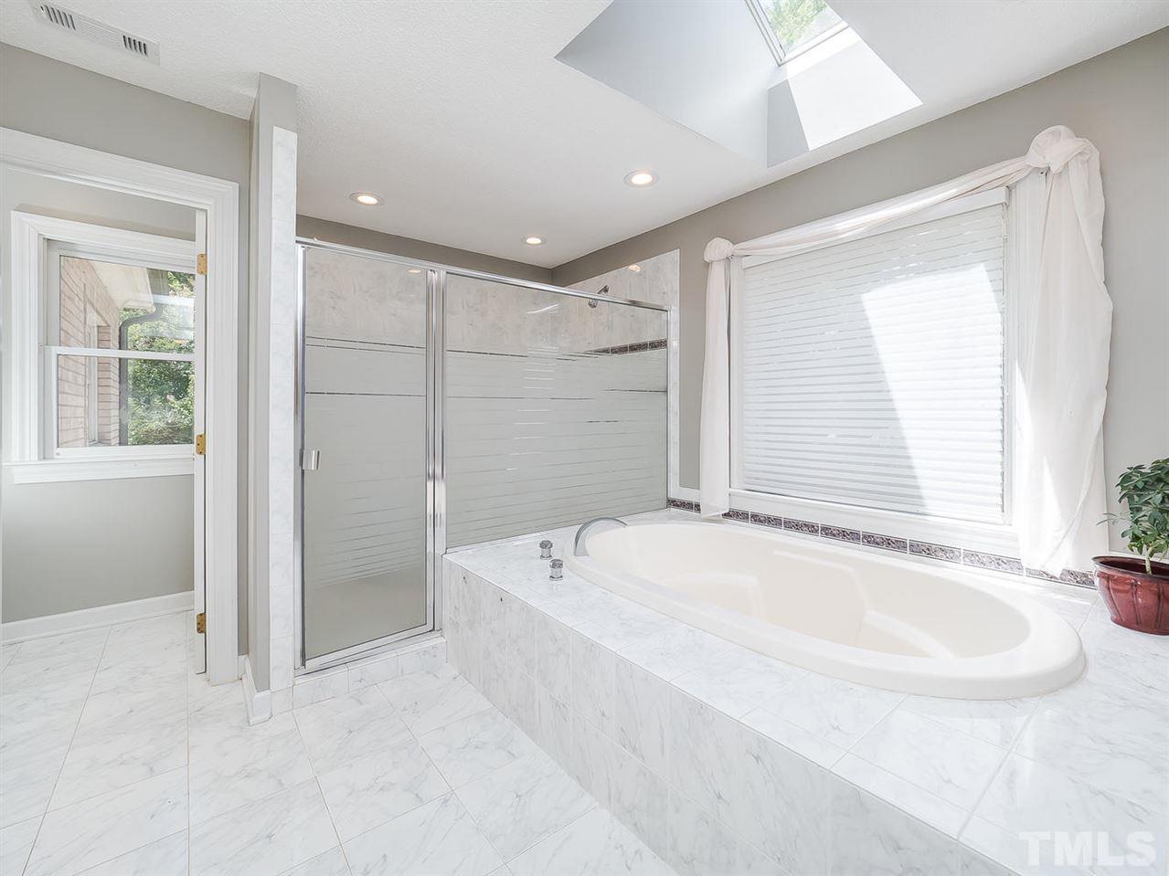409 Luther Road Apex, NC 27523 - Photo 21 of 30 Walk in shower with dual shower heads and separate over-sized tub with a skylight