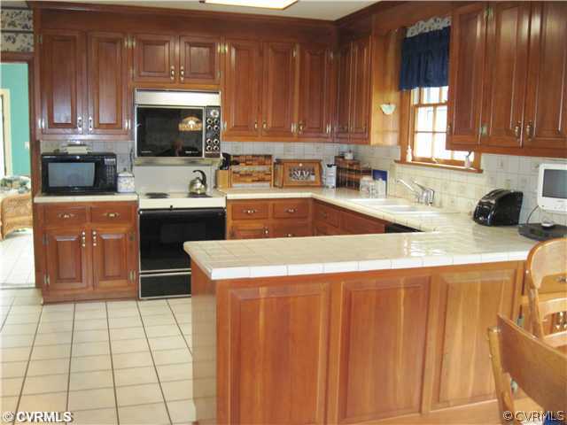 2911 Queenswood Road Midlothian, VA 23113 - Photo 5 of 12 a kitchen with a sink a stove and cabinets