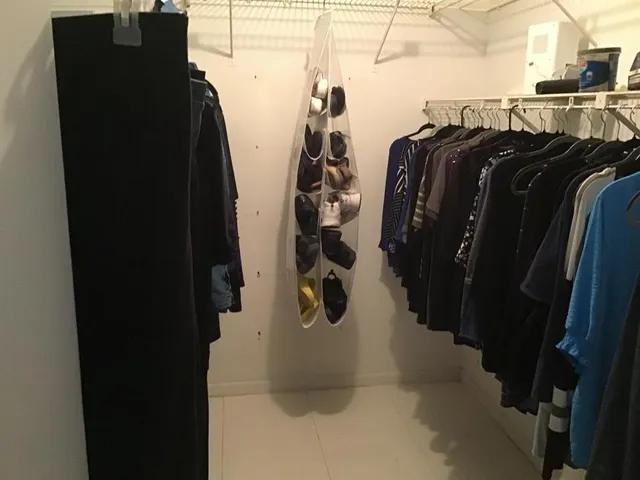a view of walk in closet with clothes and shoes