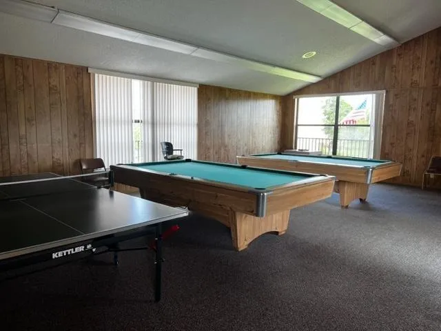 a room with pool table and windows