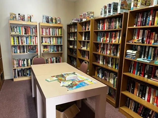 a view of a workspace with furniture and a bookshelf