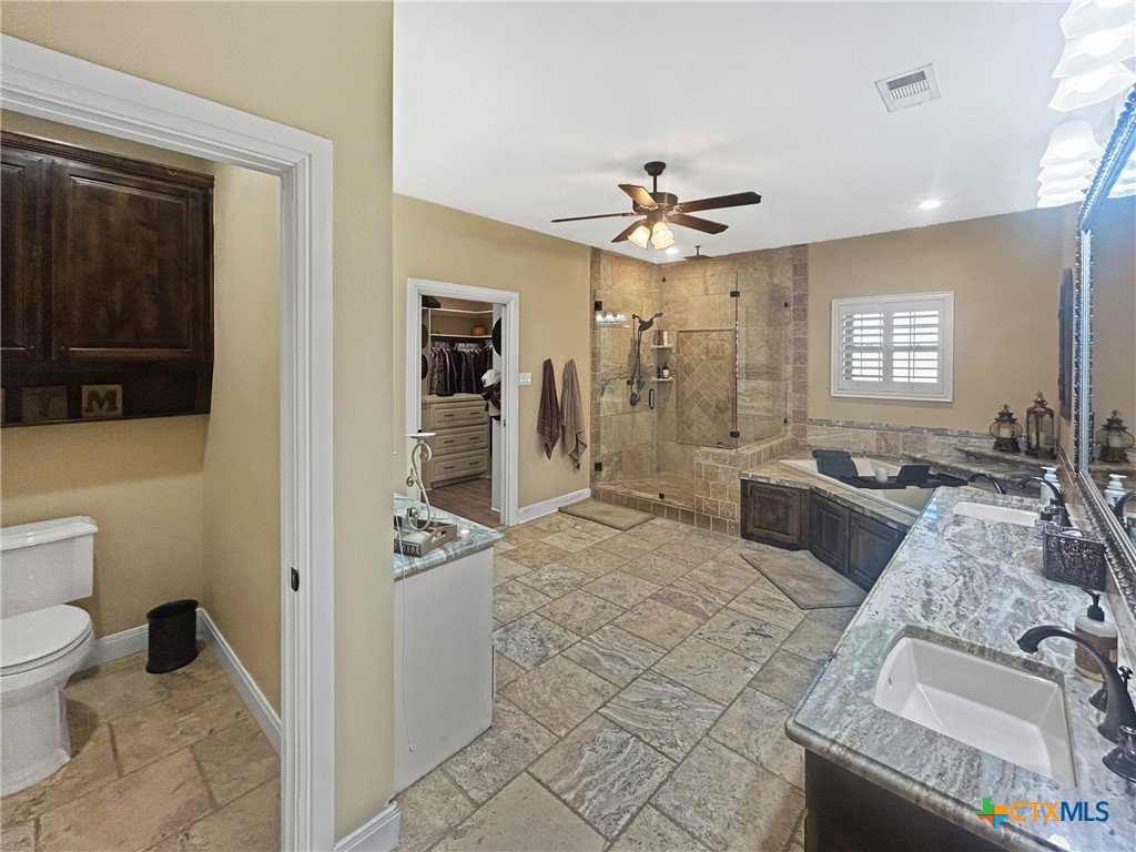 1747 Cr 139 Loop Cameron, TX 76520 - Photo 13 of 35 a spacious bathroom with a granite countertop sink a toilet a mirror and shower
