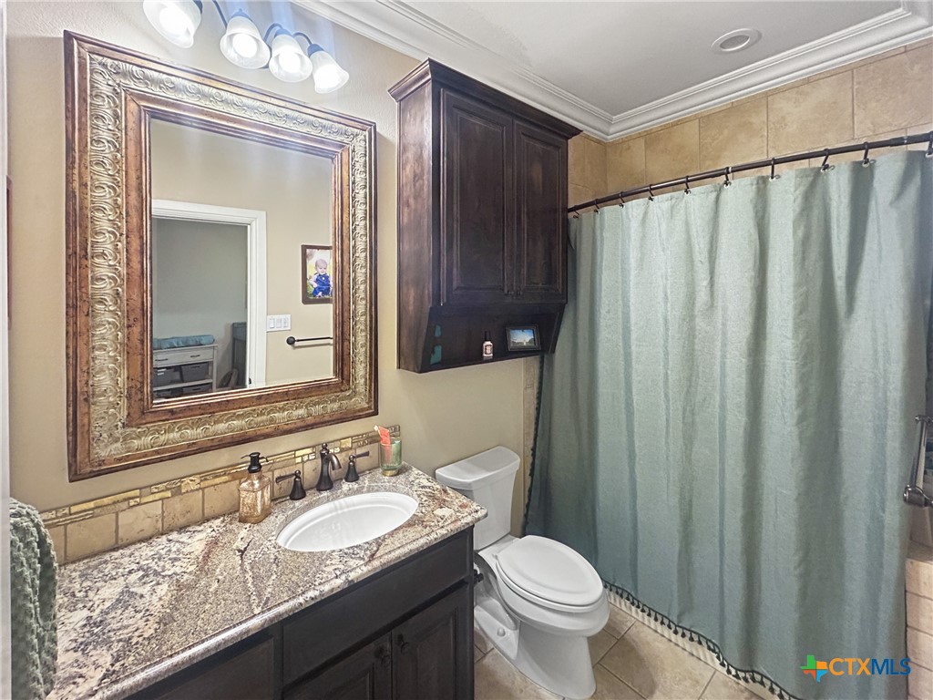 1747 Cr 139 Loop Cameron, TX 76520 - Photo 16 of 42 a bathroom with a granite countertop sink and a mirror
