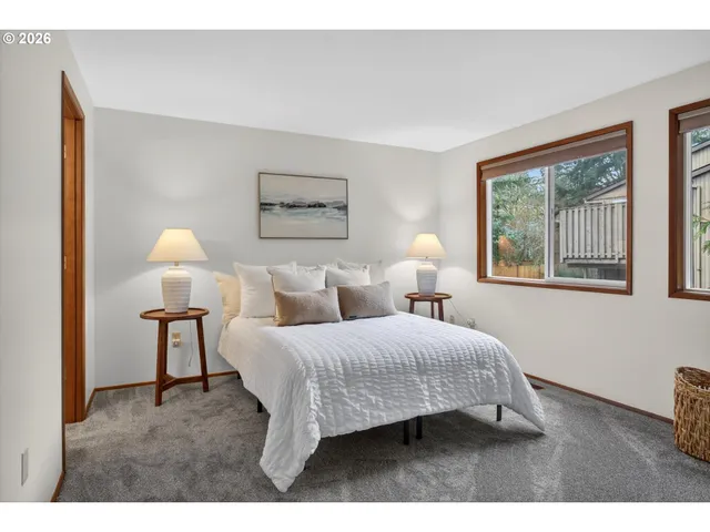 a bedroom with a bed and a lamp on dresser