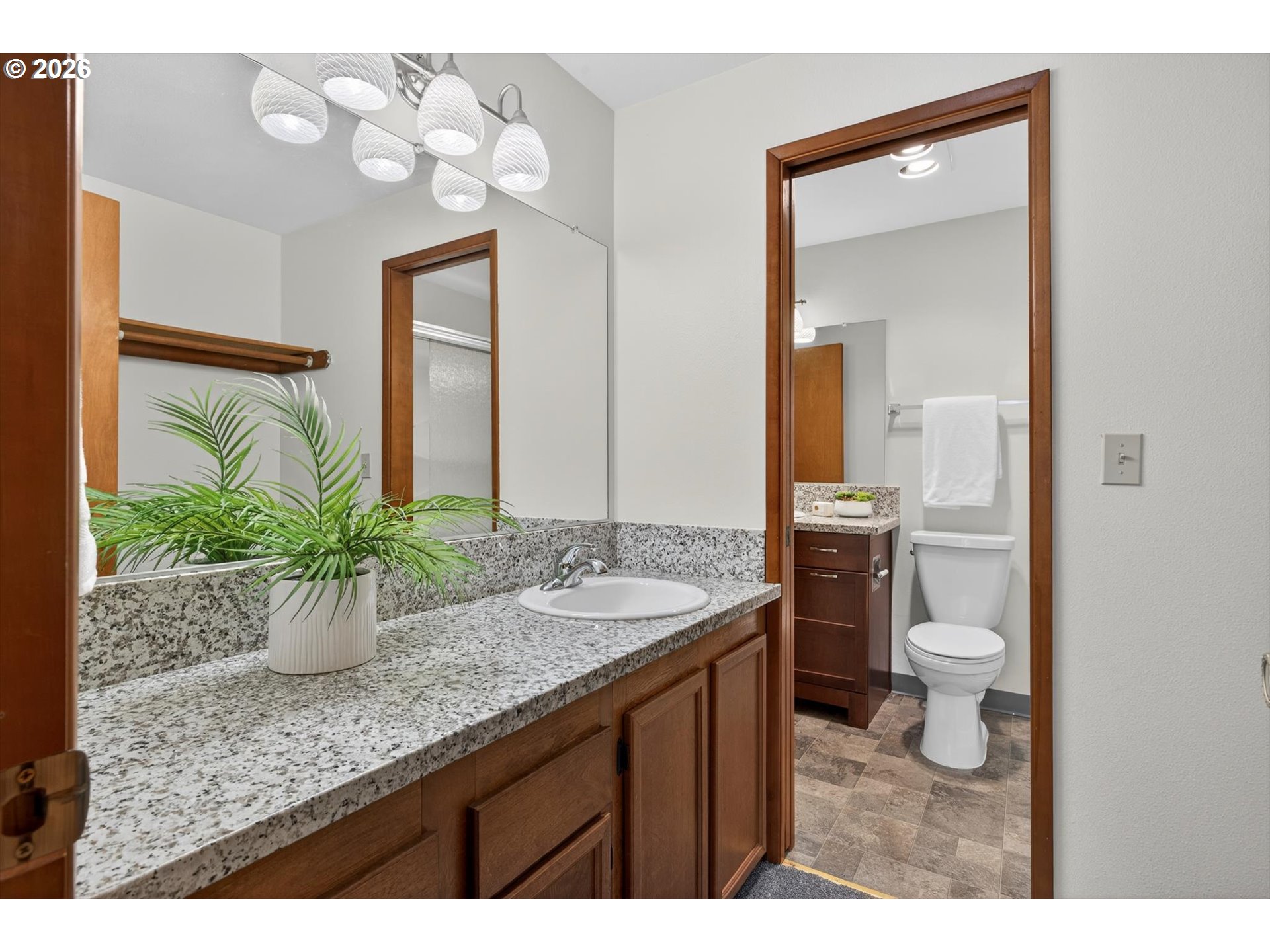 18145 Southwest Monte Verdi Boulevard Beaverton, OR 97007 - Photo 15 of 24 a bathroom with a granite countertop sink a toilet and a mirror