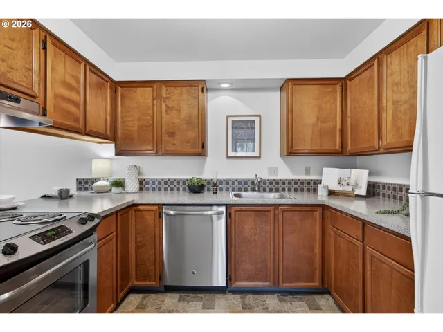 a kitchen with stainless steel appliances granite countertop a sink stove and cabinets