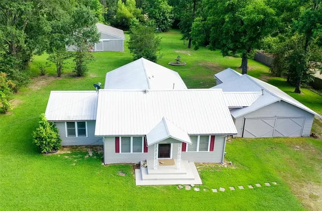 a aerial view of a house with a yard table and chairs