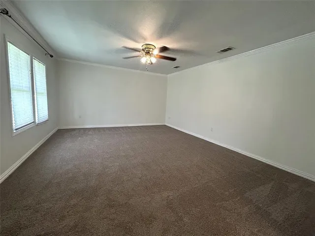 an empty room with windows and fan
