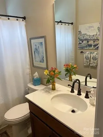 a bathroom with a sink a toilet and a mirror