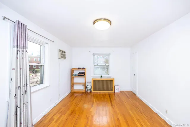 a view of a room with wooden floor and a window