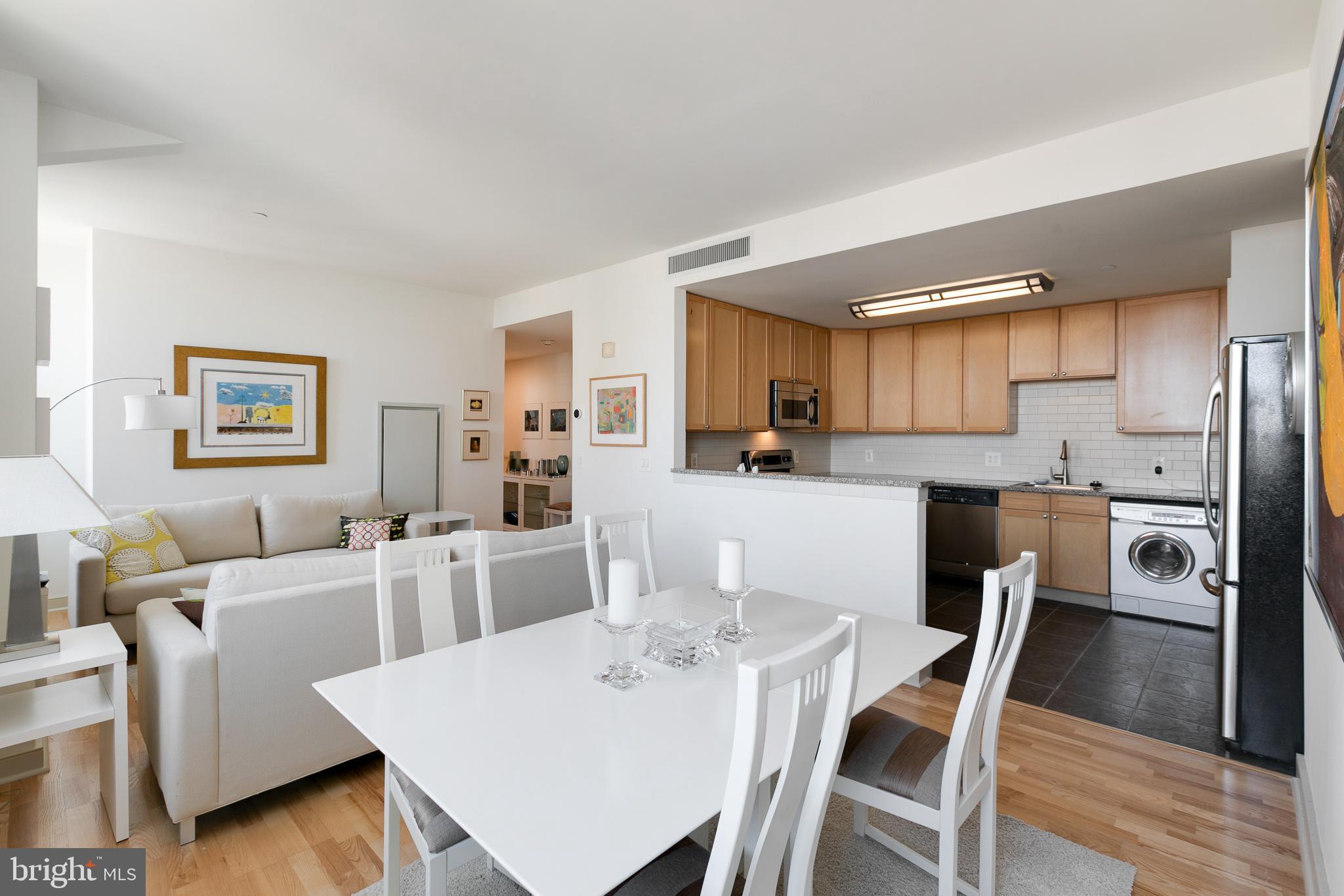 a kitchen with stainless steel appliances a dining table and chairs