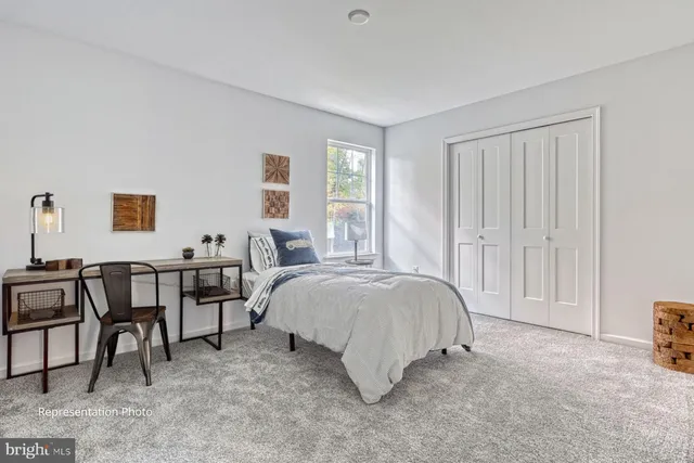 a spacious bedroom with a bed and table chair