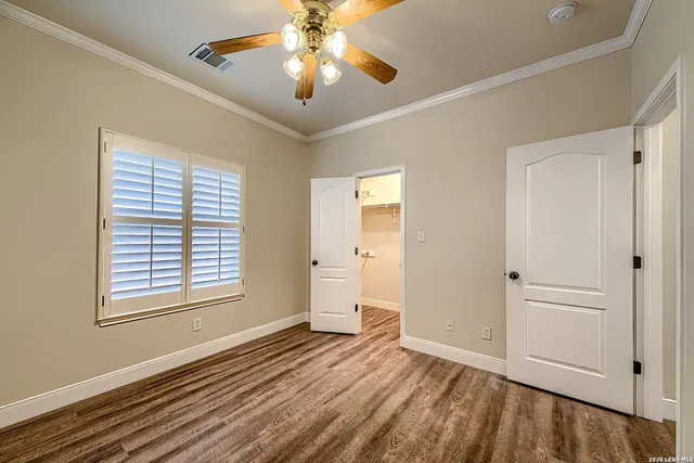 a view of an empty room with a window and a chandelier fan