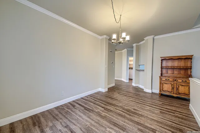 a view of a room with wooden floor and kitchen space