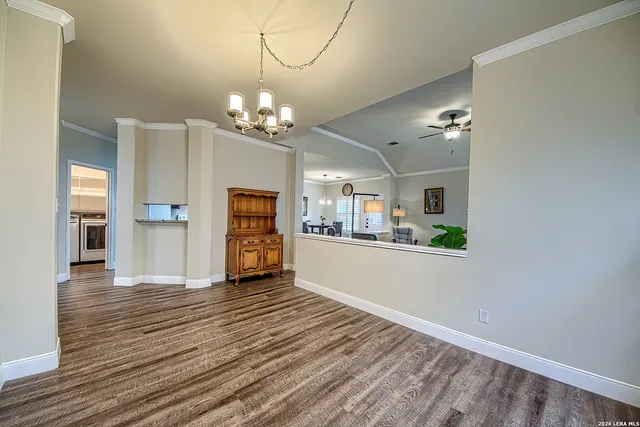 a view of a room with wooden floor and chandelier