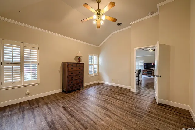 an empty room with wooden floor and a ceiling fan