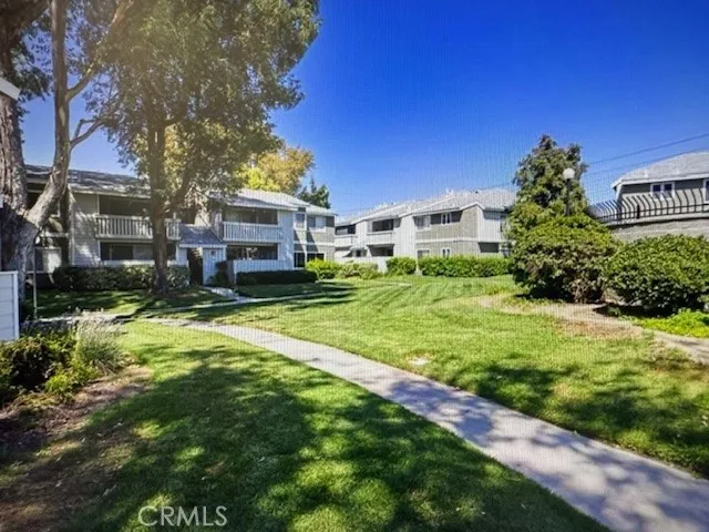 a view of a house with a big yard and large trees