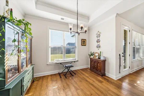 a view of a livingroom with wooden floor and windows
