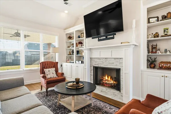 a living room with fireplace furniture and a kitchen view