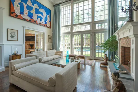 a living room with fireplace furniture and a large window