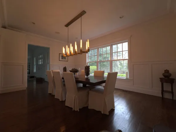a view of a dining room with furniture a chandelier and wooden floor