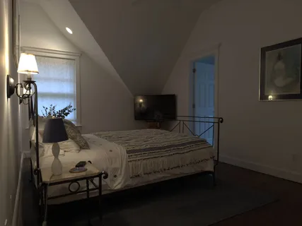 a bedroom with a bed a mirror and lamp