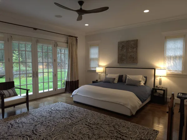 a bedroom with a bed and a lamp on dresser