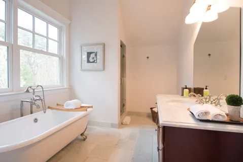 a bathroom with a tub sink and mirror