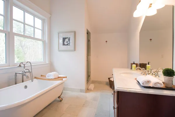 a bathroom with a tub sink and mirror