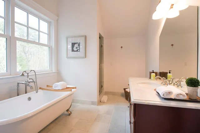 a bathroom with a tub sink and mirror