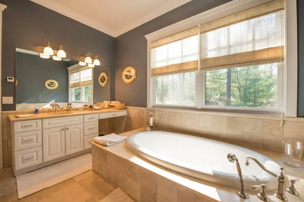 a bathroom with a granite countertop sink mirror and a large window