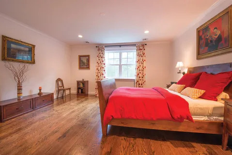 a bedroom with a bed and wooden floor