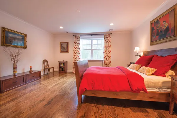 a bedroom with a bed and wooden floor