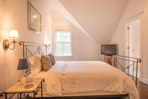 a bedroom with a bed and chair with table
