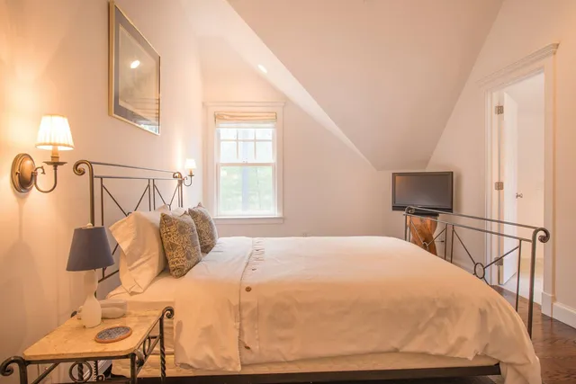 a bedroom with a bed and chair with table