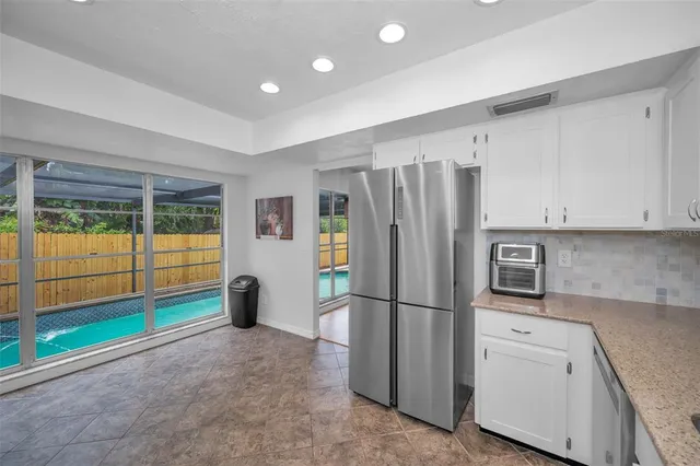 a kitchen with stainless steel appliances granite countertop a sink refrigerator and cabinets