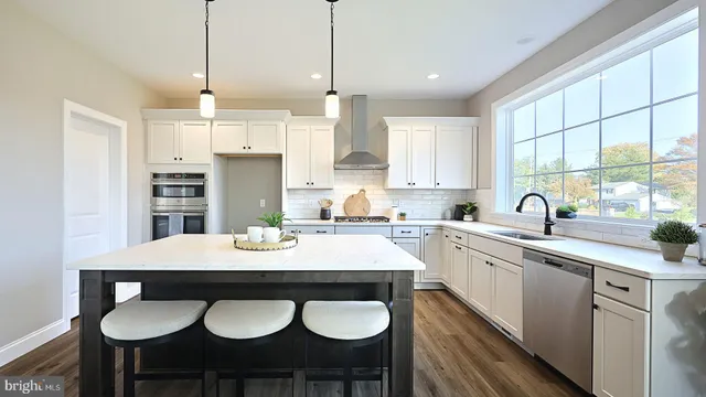 a kitchen with stainless steel appliances granite countertop a sink a stove a table and chairs