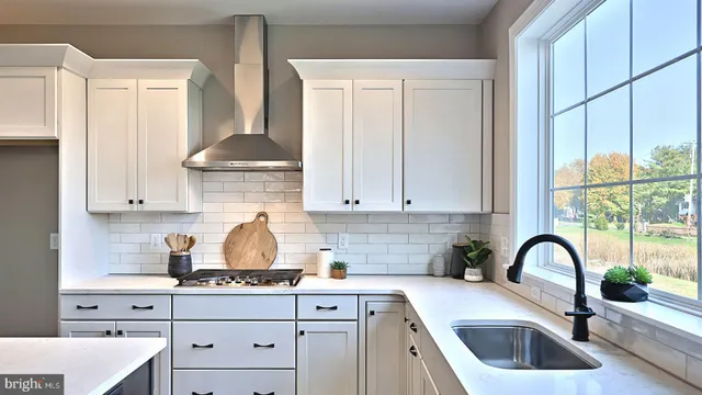 a kitchen with stainless steel appliances granite countertop a sink a stove and a window