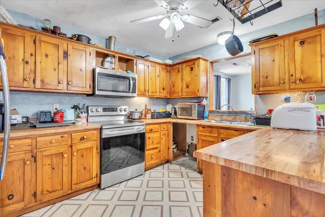 a kitchen with stainless steel appliances granite countertop a sink a stove and cabinets