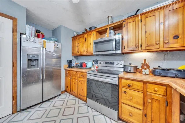 a kitchen with stainless steel appliances granite countertop a refrigerator stove and sink