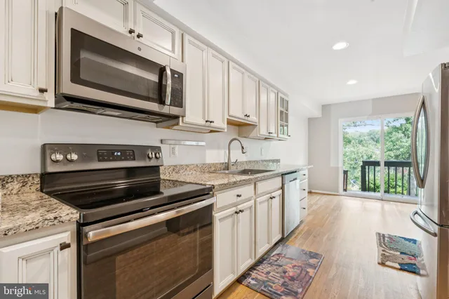 a kitchen with stainless steel appliances granite countertop a stove microwave and sink