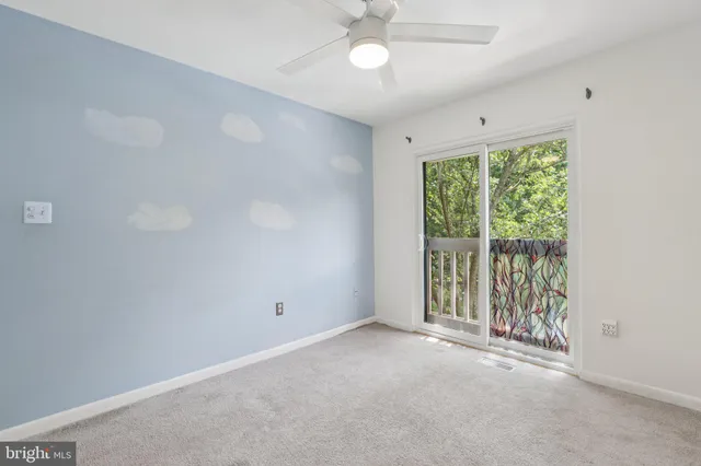 an empty room with a ceiling fan and a window