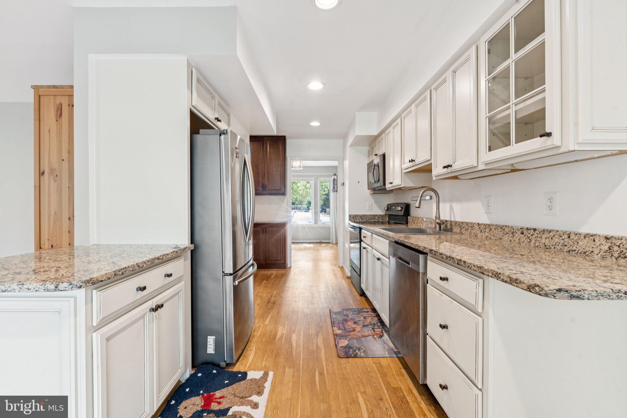2009 Swans Neck Way Reston, VA 20191 - Photo 8 of 37 a kitchen with granite countertop kitchen island wooden floors granite counter tops and white appliances