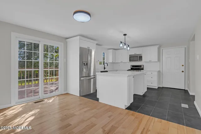 a view of a big room with wooden floor and windows