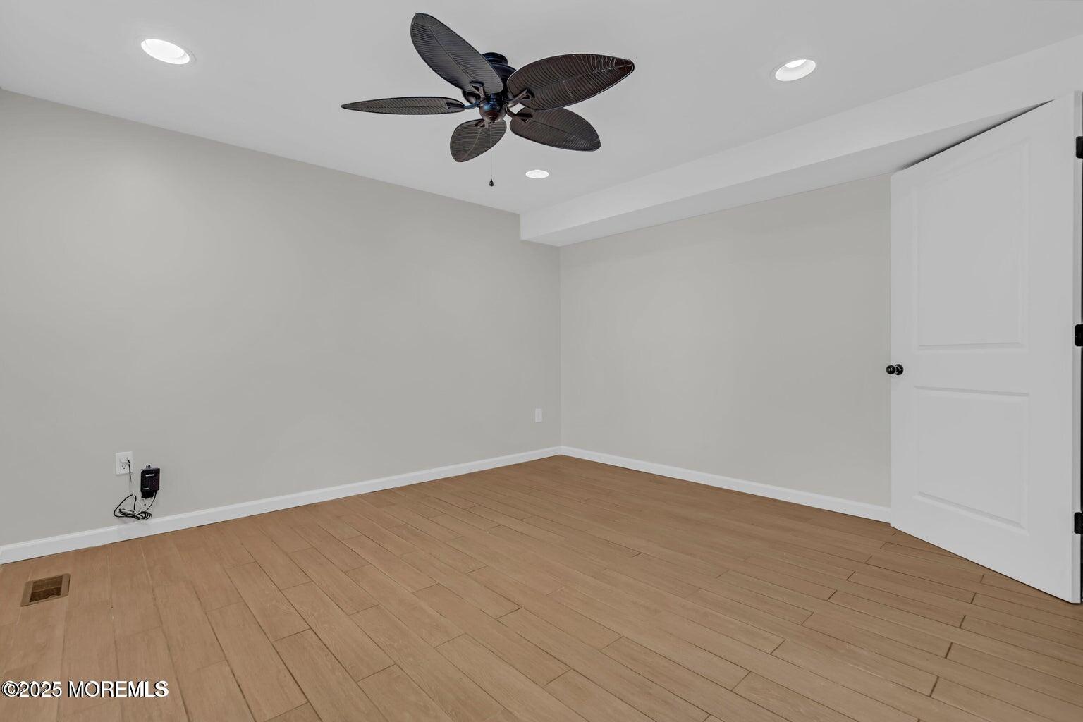 58 Garden Avenue Island Heights, NJ 08732 - Photo 38 of 46 an empty room with a ceiling fan and wooden floor