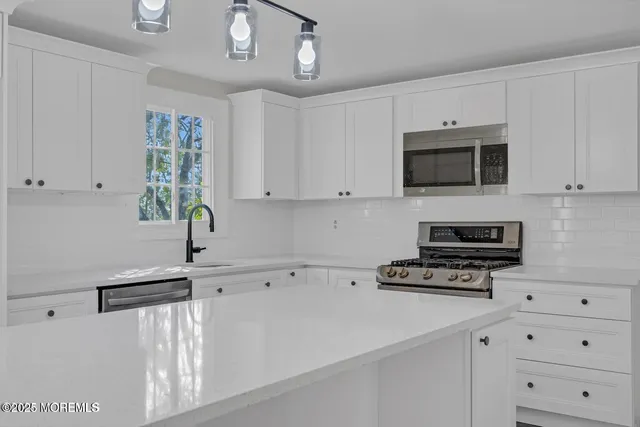 a kitchen with cabinets appliances and a ceiling fan