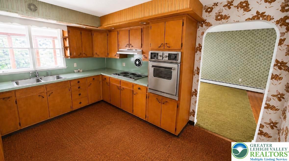 1306 Trexlertown Road Macungie, PA 18062 - Photo 4 of 11 This vintage kitchen features ample cabinetry and a functional layout, seamlessly connecting to an adjacent living space.